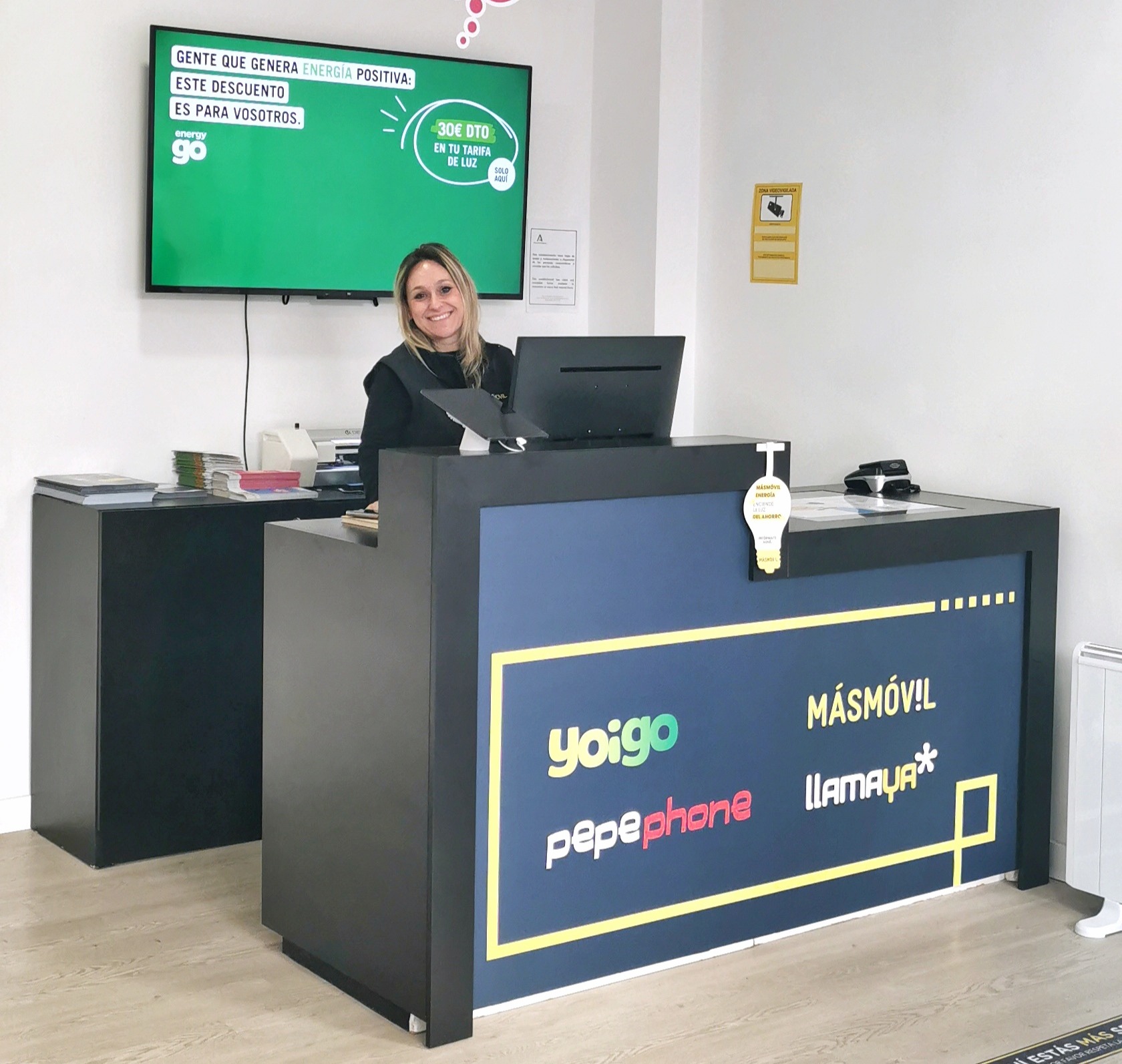 Interior de la tienda de telefonía en La Zubia con asesora atendiendo